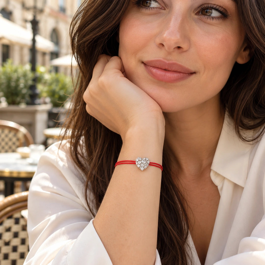 Coralie 925 ayar gümüş yaklaşık 13 mm kalp bileklik, beyaz bluzlu kadın modelde dış mekân kullanımı